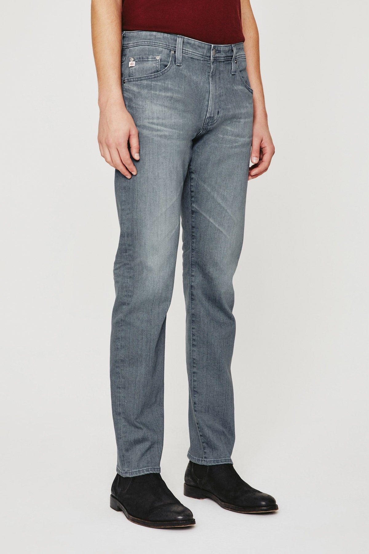 model wearing ag jeans tellis modern slim jean in 17 years gibson grey, shown from the waist down