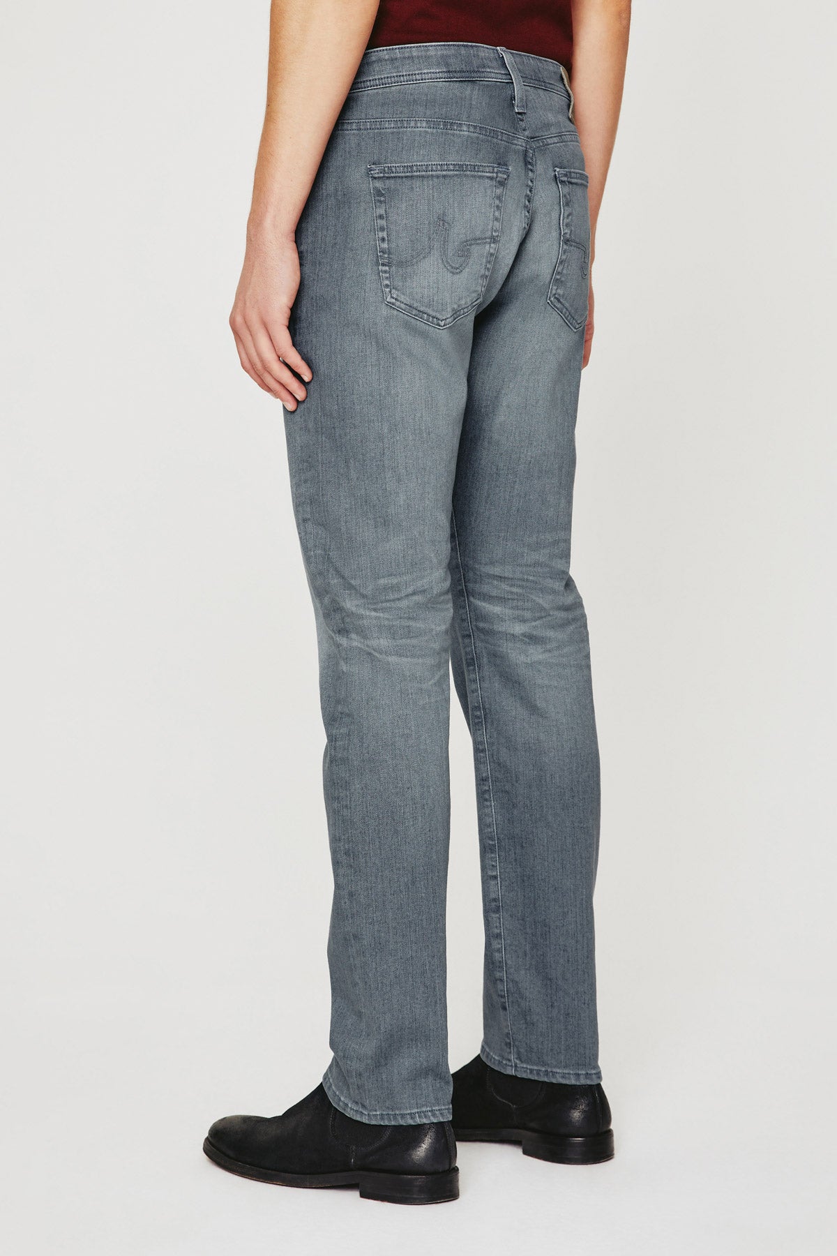 model wearing ag jeans tellis modern slim jean in 17 years gibson grey, showing the rear