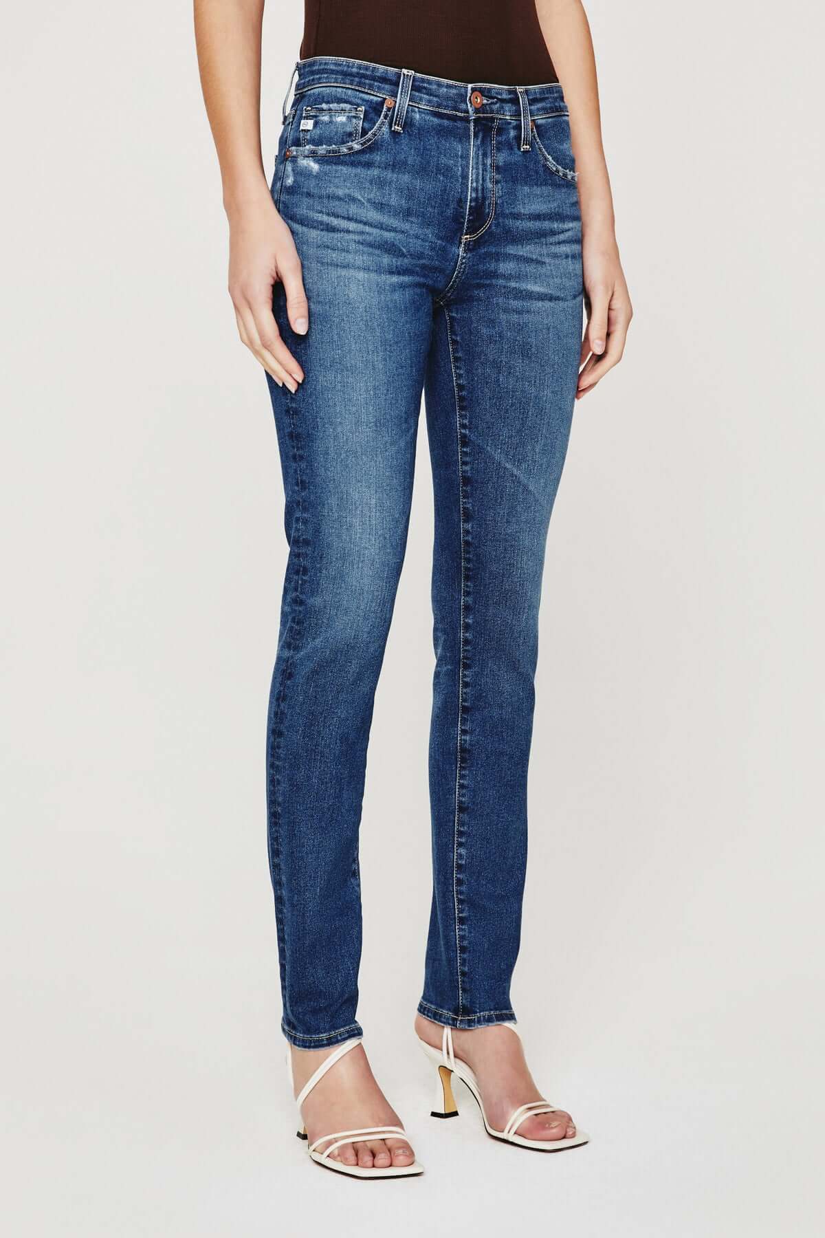 model wearing ag jeans prima mid rise slim jean in brighton blue, shown from the waist down
