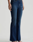model standing at an angle wearing ag jeans farrah boot cut in kindling blue, shown from the waist down