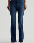 model facing forward wearing ag jeans farrah boot cut in kindling blue, shown from the waist down