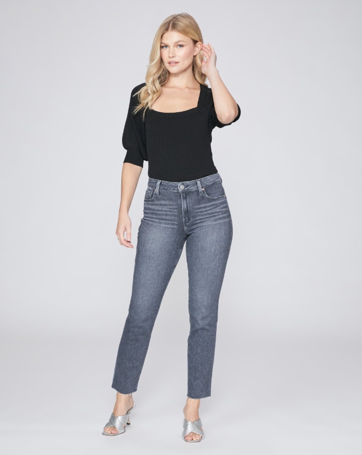 full body view of the cindy jean with raw hem from paige in grey, styled with a black top