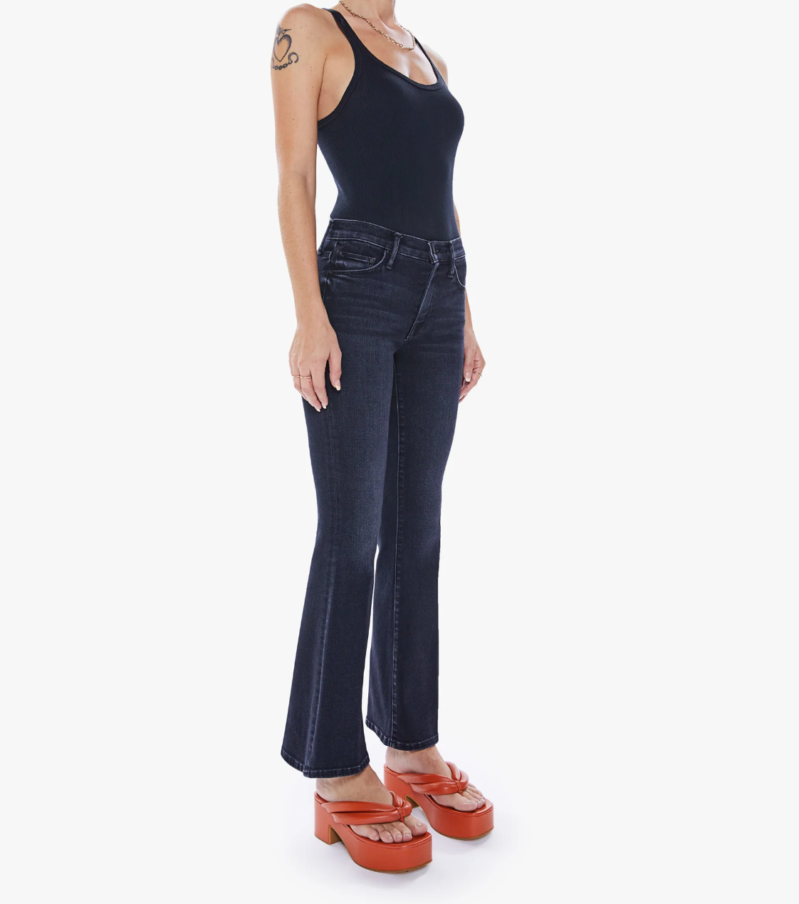 front view of the weekender flare jean in deep end black, styled with a black tank and orange sandals