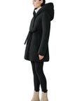 Woman wearing a black coat with a hood on a white background