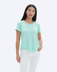 model wearing chrldr ava mock layer t shirt in light green, with white pants