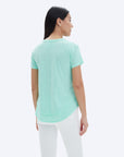 model wearing chrldr ava mock layer t shirt in light green, shown from the back