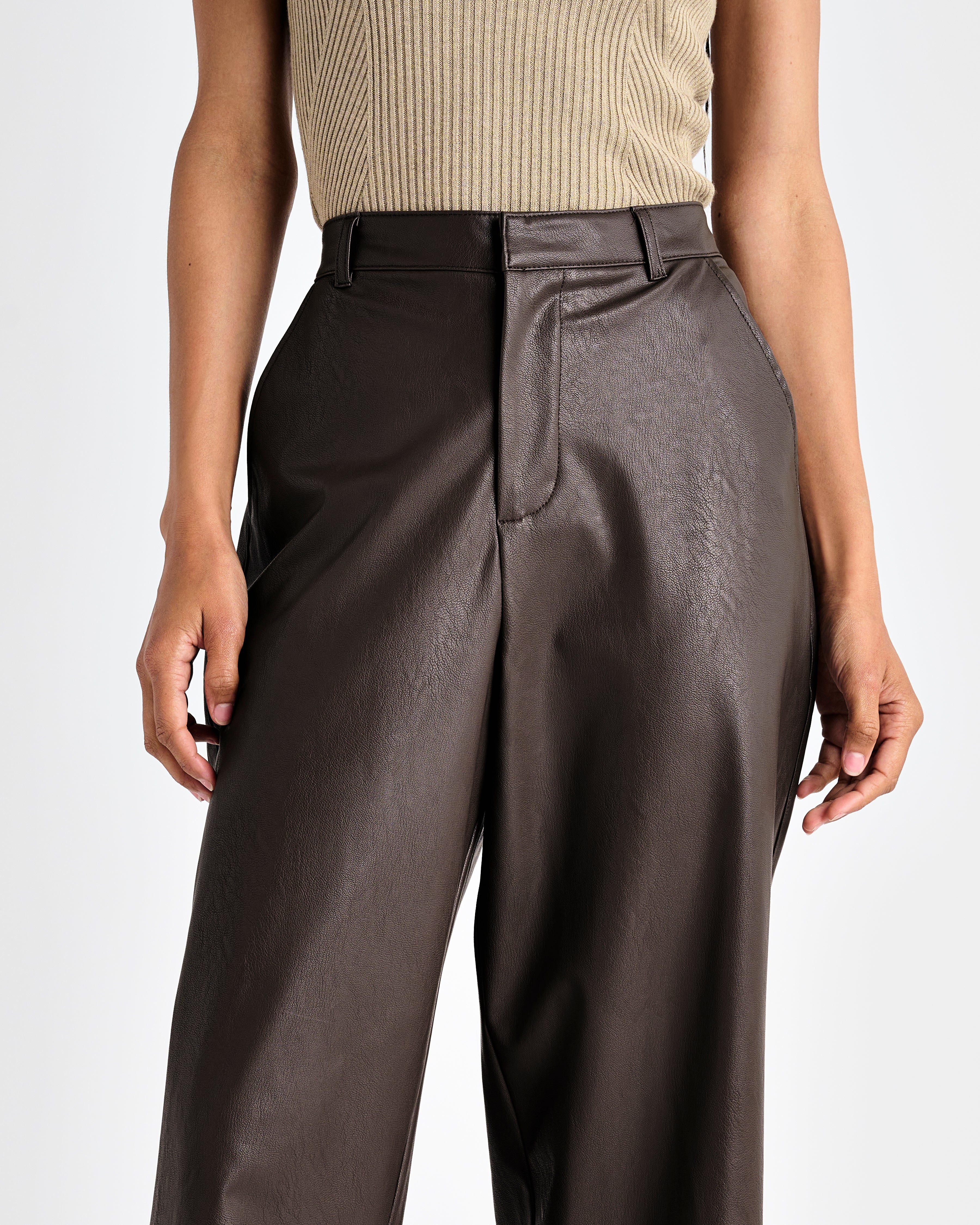 close up of the waistline of the dark brown vegan leather ankle length wide leg trousers
