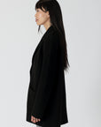 model wearing genie knit boyfriend blazer in black, side view