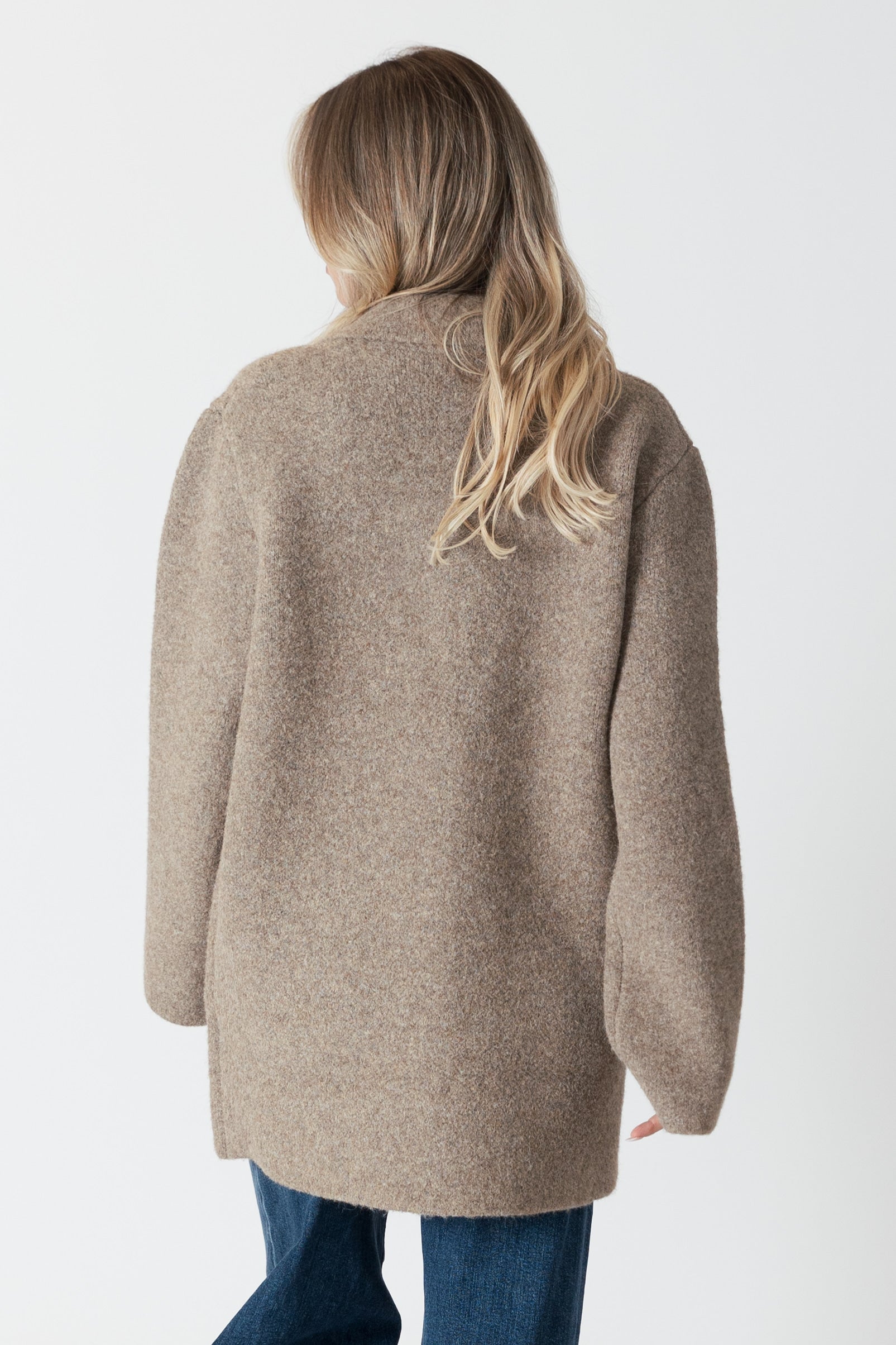 model wearing genie knit boyfriend blazer in beige, rear view