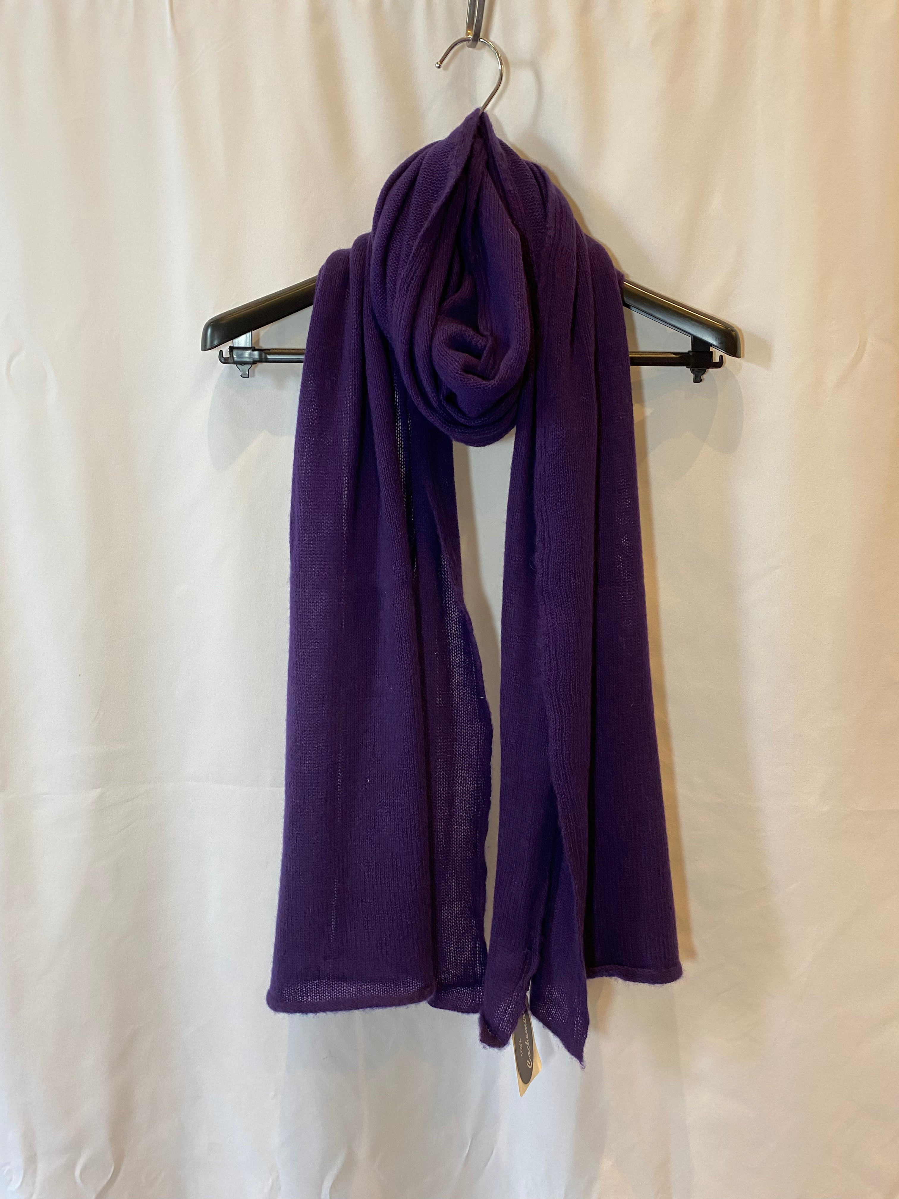 purple cashmere scarf displayed on a hanger