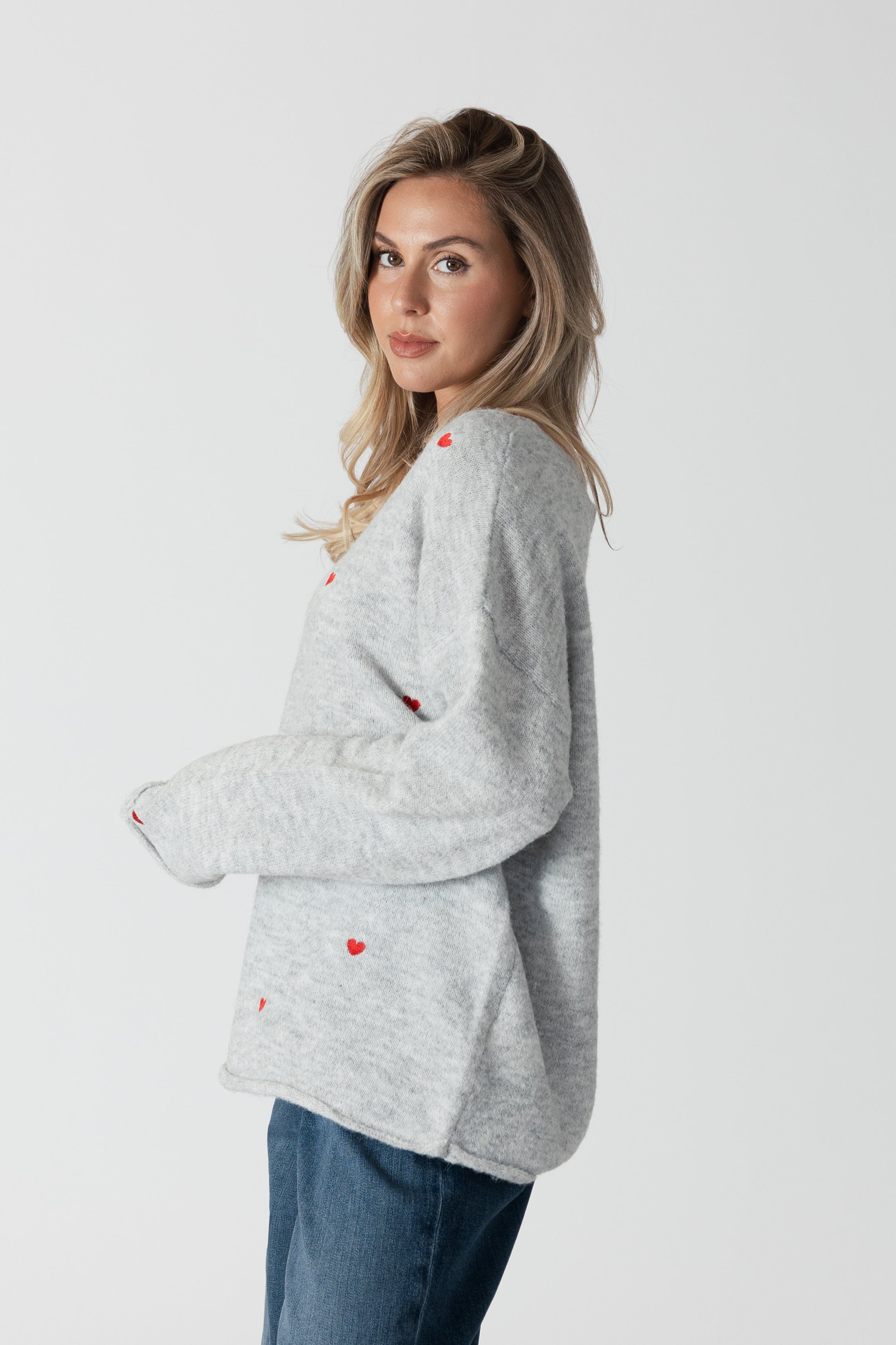 model wearing lyla & luxe luna v-neck embroidered hearts sweater, side view