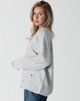 model wearing lyla & luxe luna v-neck embroidered hearts sweater, side view