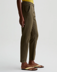 model facing to the side wearing caden tailored trouser in sulfur shady moss green, shown from the waist down