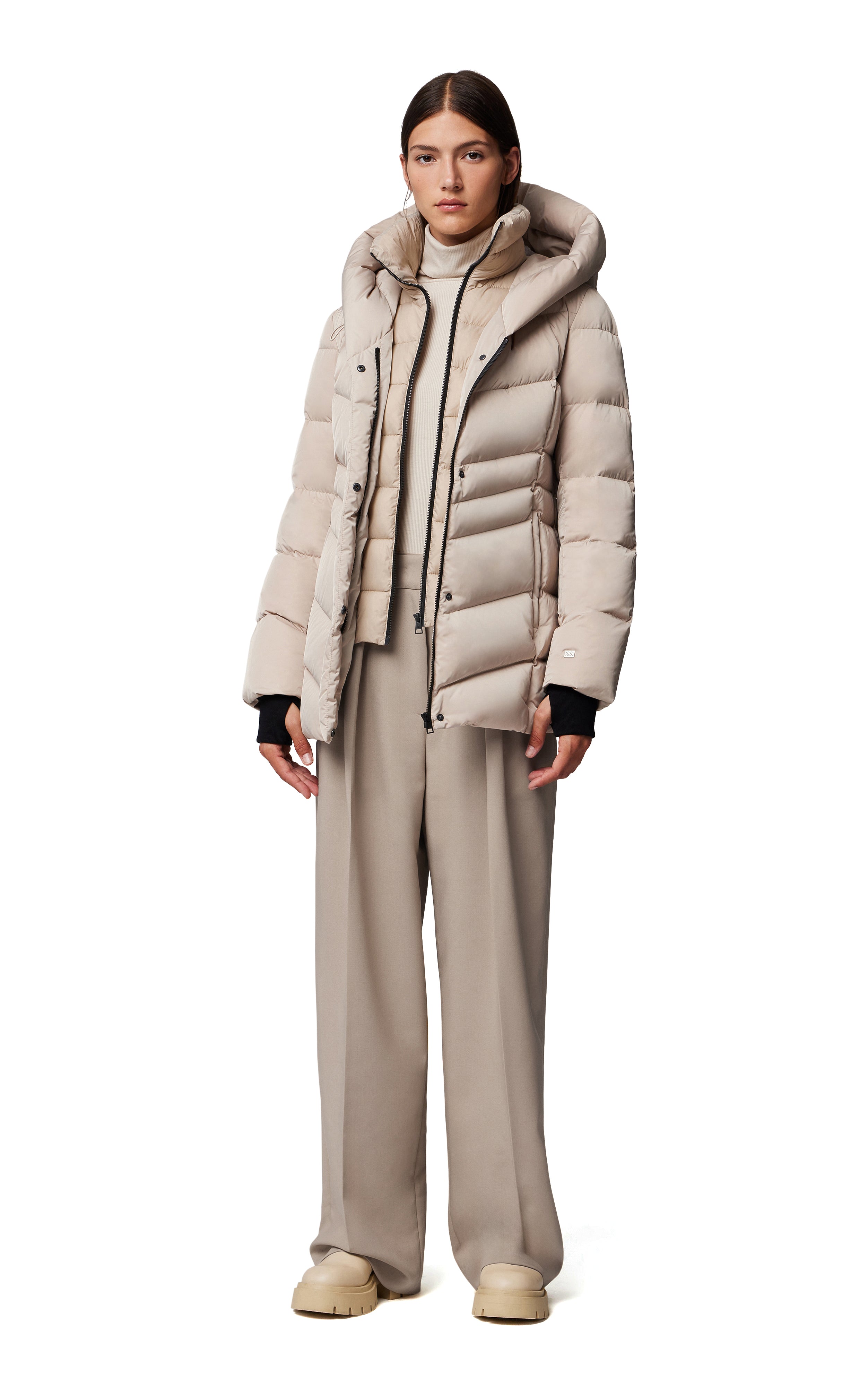 side view of the tallia mid length hooded parka in beige, unzipped and styled with tonal pants