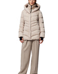 front view of the tallia mid length hooded parka in beige, zipped up and styled with tonal pants