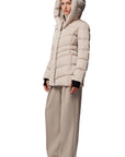 side view of the tallia mid length hooded parka in beige, zipped up and styled with tonal pants