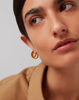 model wearing the jenny bird nautilus shaped dylan earrings in gold